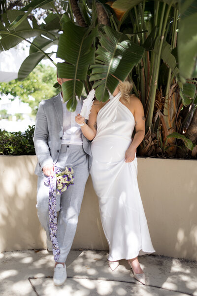 bride-and-groom-with-palm-tree-covering-their-face-miami-beach-courthouse