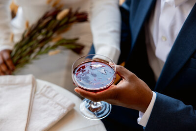 Bride and groom gives a toast from sweetheart table | Lawrence + Nathalie