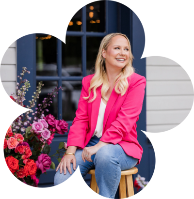 Bloom Bar founder smiling among bold pink florals, representing creative direction and Austin event styling expertise.