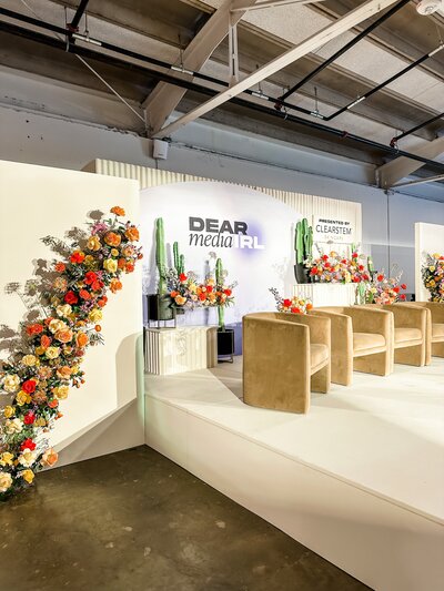 Branded event stage design with bold florals and modern cactus arrangements for an Austin corporate event activation.