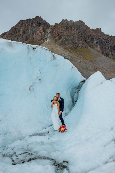 groom holding onto bride from behind at their Alaska glacier elopement