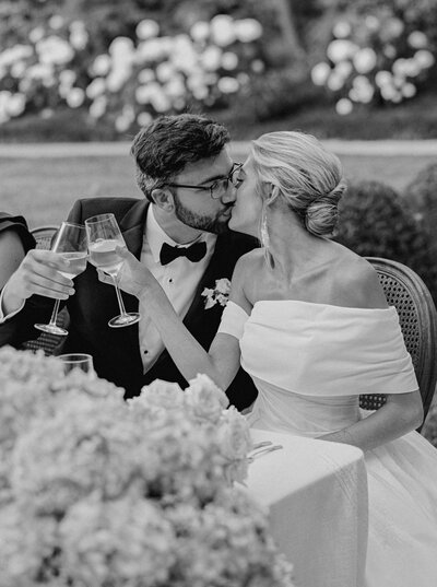 Bride and groom kiss and clink champagne glasses at Castle and Key Distillery in Lexington Kentucky photographed by Lexington Kentucky luxury film wedding photographer Magnolia Tree Photo Company