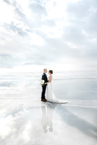 Newly married couple standing on beach