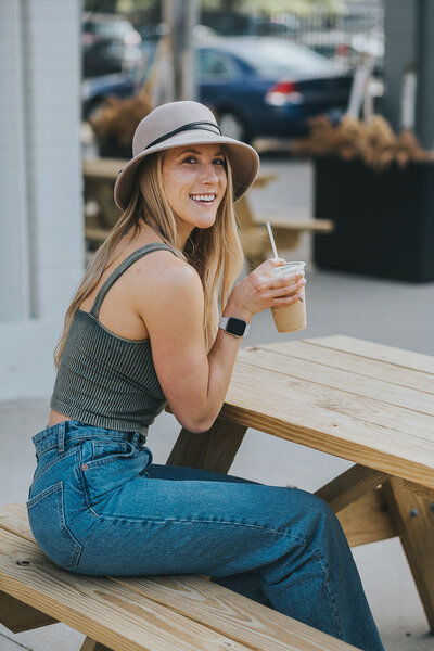 woman sitting on a picnic bench with coffee