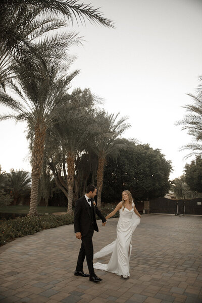 bride and groom hold hands at san diego wedding venue
