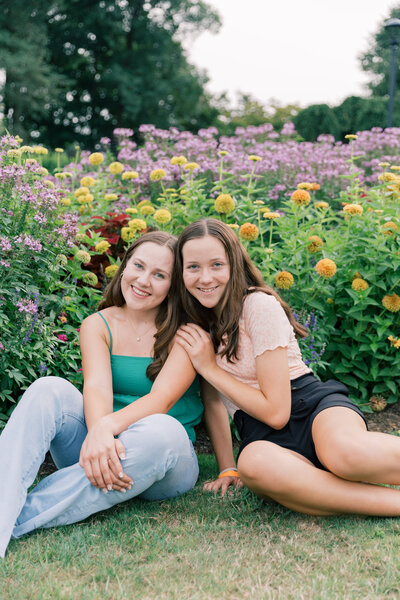 Sisters smiling in front of colorful flowers at Hershey Gardens