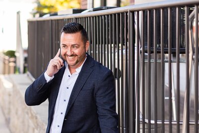 Male business owner smiling and talking on the phone at branded photography session by Danielle Hardesty Photography