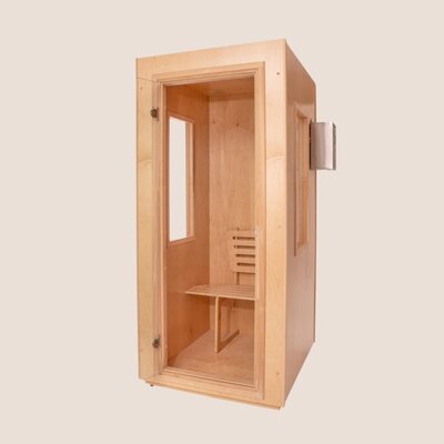 A small, wooden salt therapy booth with a glass door and side window. Inside, a simple wooden chair and a small bench offer a quiet retreat, reminiscent of a cozy massage therapy space in Tolleson, Arizona. Set against a plain, light background.