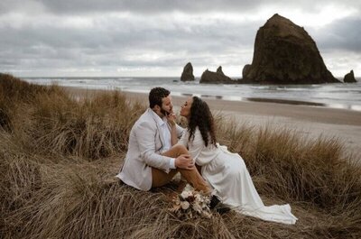 A professional photo of a bride and groom sharing a romantic moment on the dunes at Cannon Beach.