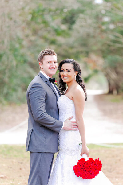 A Georgia bride and groom pose in a field for Photography by Karla