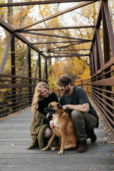 Portrait of Natalie Dyer, founder of Natalie Dyer Photo, with her husband and dog in Fort Collins, Colorado, showcasing their family in a warm and welcoming setting.