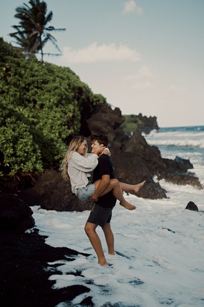 man holding woman on beach