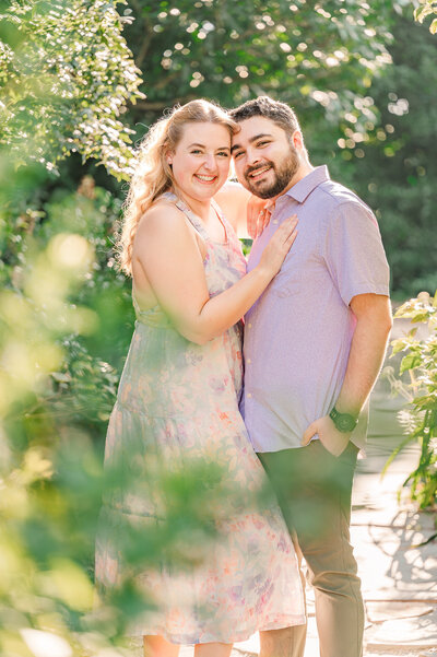 A happily engaged couple in Airlie Gardens at sunset by JoLynn Photography, a Wilmington wedding photographer