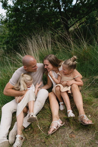Familie knuffelt en speelt op een mooi grasveld