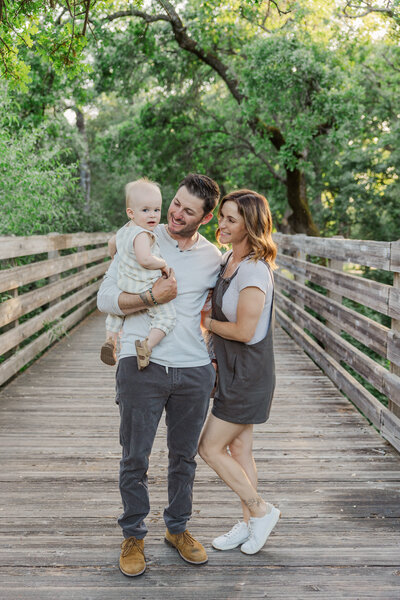 Beautiful family laughing together in Sacramento, CA park during their family photography by Caroline Bendel