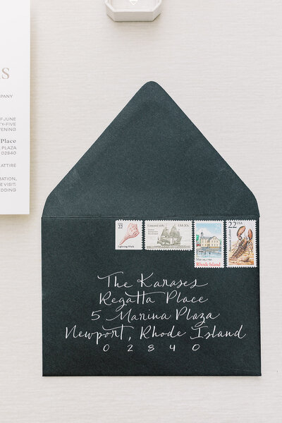 Black envelope with white calligraphy and vintage postage for wedding at Regatta Place in Newport, Rhode Island.