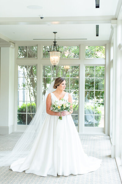 bride posing by wall of windows