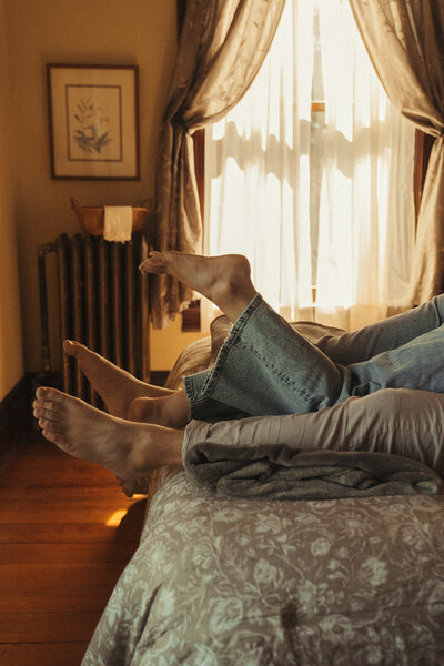 Engaged couple lays on bed of Minnesota mansion