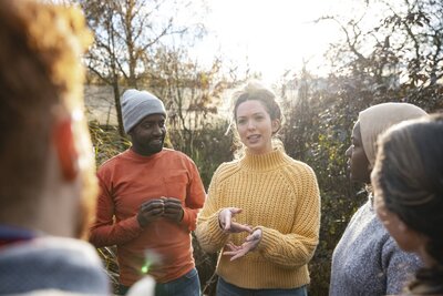 A leader standing outside speaking to a group