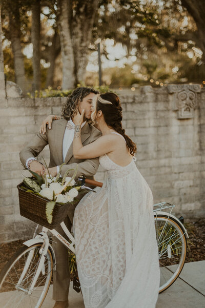 Couple kissing on bicycles on their Tulum elopement
