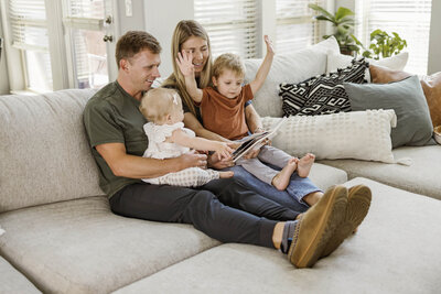 family of 4 reads a book in their carrollton home