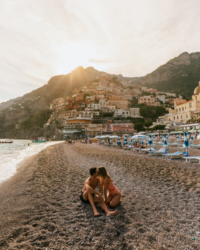 man and woman kissing in sand positano italy