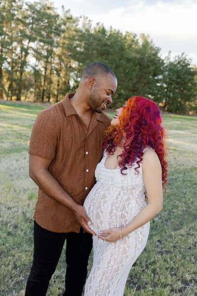 maternity photo of woman in white dress in the desert at sunset