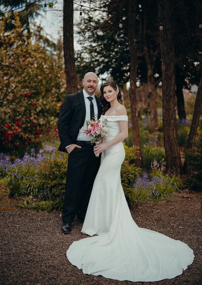 a bride and groom posing for a wedding portrait