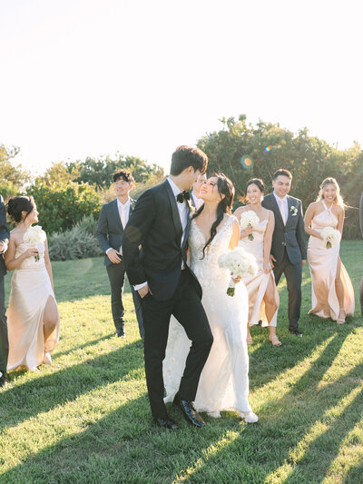 walking photo of bride and groom  on the lawn with bridal party