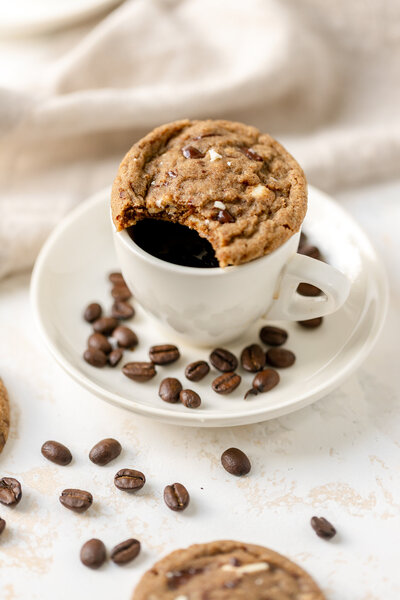 a cookie sitting on top of a mug with coffee in it