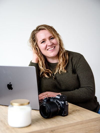 Kristin Wieskamp, Pittsburgh birth photographer and certified doula, smiling and holding her camera.