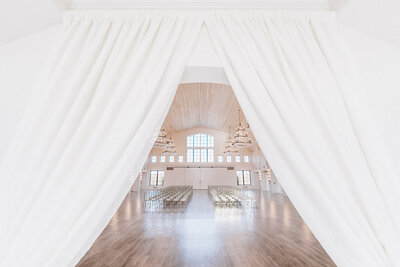 elegant white curtains cascading open as you walk through the archway into an elegant white venue