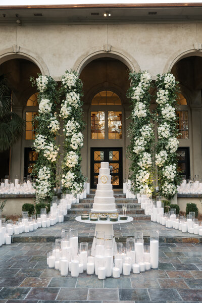Tented luxury wedding with pink and green floral display and a couch setup. Destination wedding planner, Passera Events