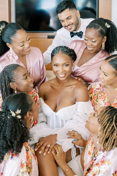 Bride surrounded by her bridesmaids in matching robes during wedding morning preparations, photographed by a Toronto wedding photographer