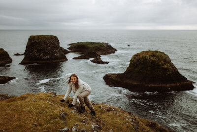 en elopement fotograf klättrar upp för ett berg
