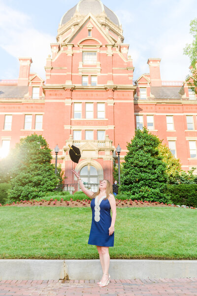 Johns Hopkins grad tosses cap on the Johns Hopkins Medical Campus during Johns Hopkins Grad session