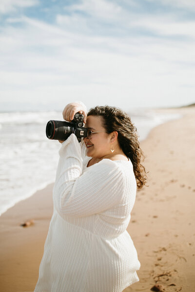 A solo portrait of the side profile of Valerie Doucette, a wedding, engagement, elopement, couples photographer taking a photo of the sea