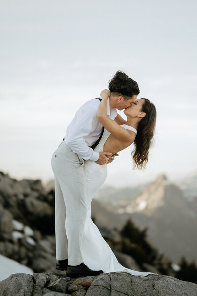 Couple kissing on a mountaintop for a romantic mountaintop elopement photo
