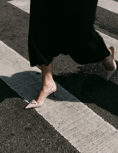 Lady wearing high heels walking across a crosswalk