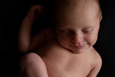 Een waardevolle herinnering uit een newborn shoot aan huis. Baby op zwarte achtergrond. Irene Maris Fotografie.