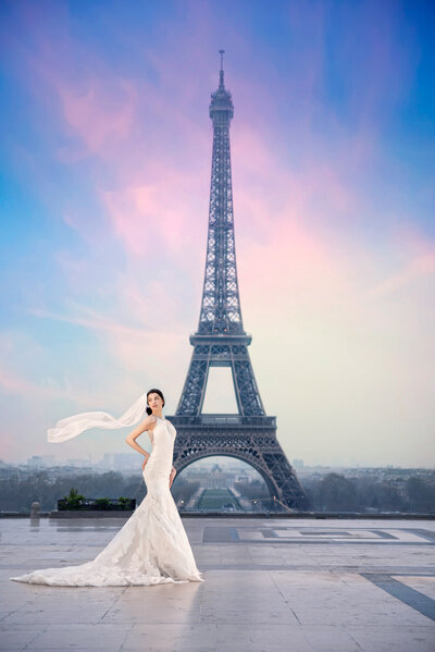 Gorgeous bride in her wedding gown in front of the Eiffel Tower in Paris