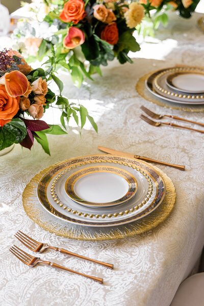 orange roses and yellow flower centerpieces with mixed metal place settings