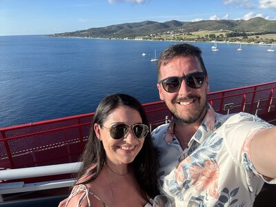 Jessica with her husband in front of the ocean