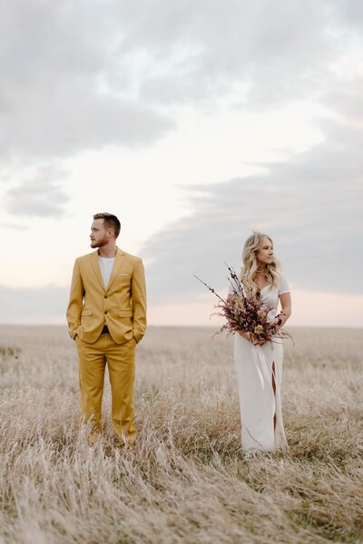 Married Couple standing in grass field