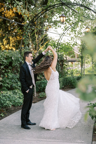 Bride and groom stroll through lush greenery at their Wolf Lakes Park wedding