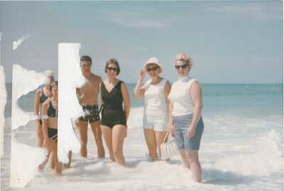 a family standing in the ocean in the 1960s.