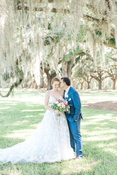 Bride and groom share a kiss at the Magnolia Plantation and Gardenss by Karen Schanely.