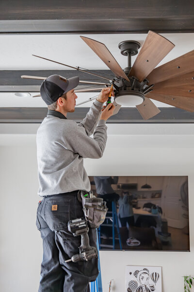 Electrician in Albuquerque installing ceiling fan 