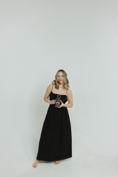 woman smiling while holding a camera