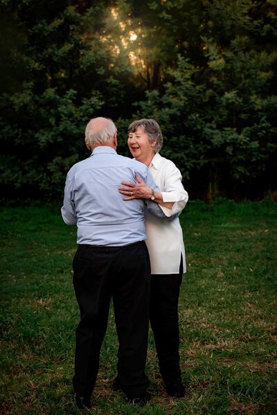 Older couple embracing below  a willow tree
